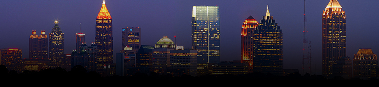 City skyline at night with illuminated buildings.